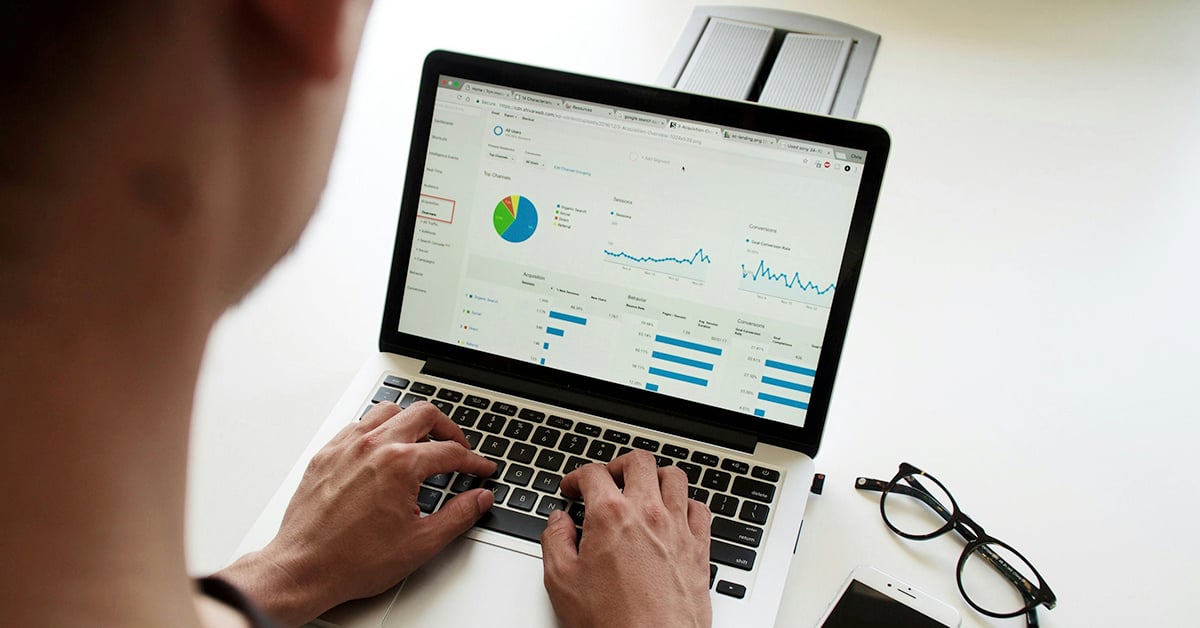 A male employee viewing analytics on his computer that indicate the ROI that a vCISO or CISO can bring to a business.