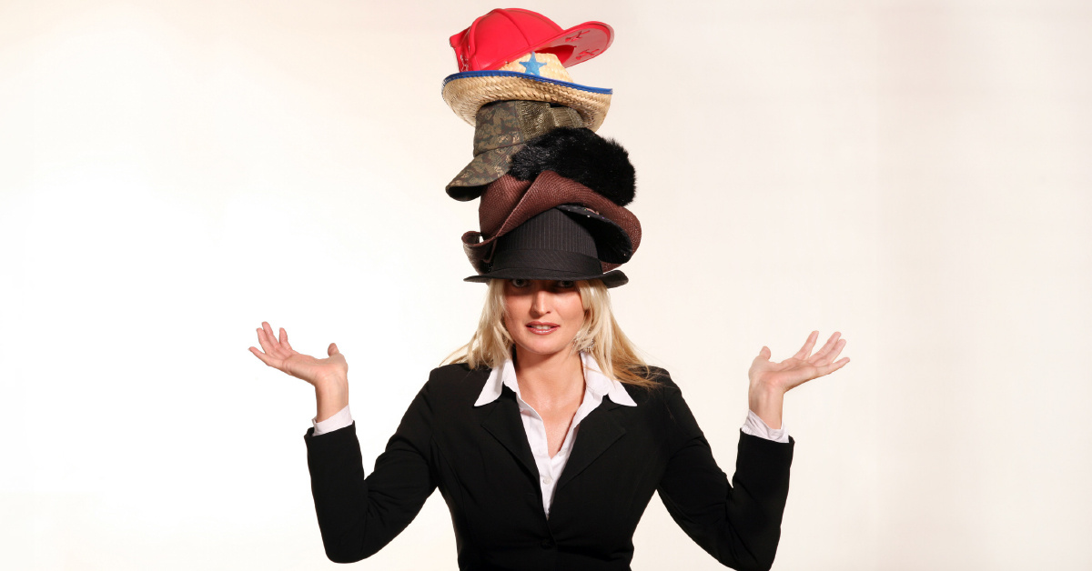 A female business owner wearing too many hats, highlighting the need for IT outsourcing.