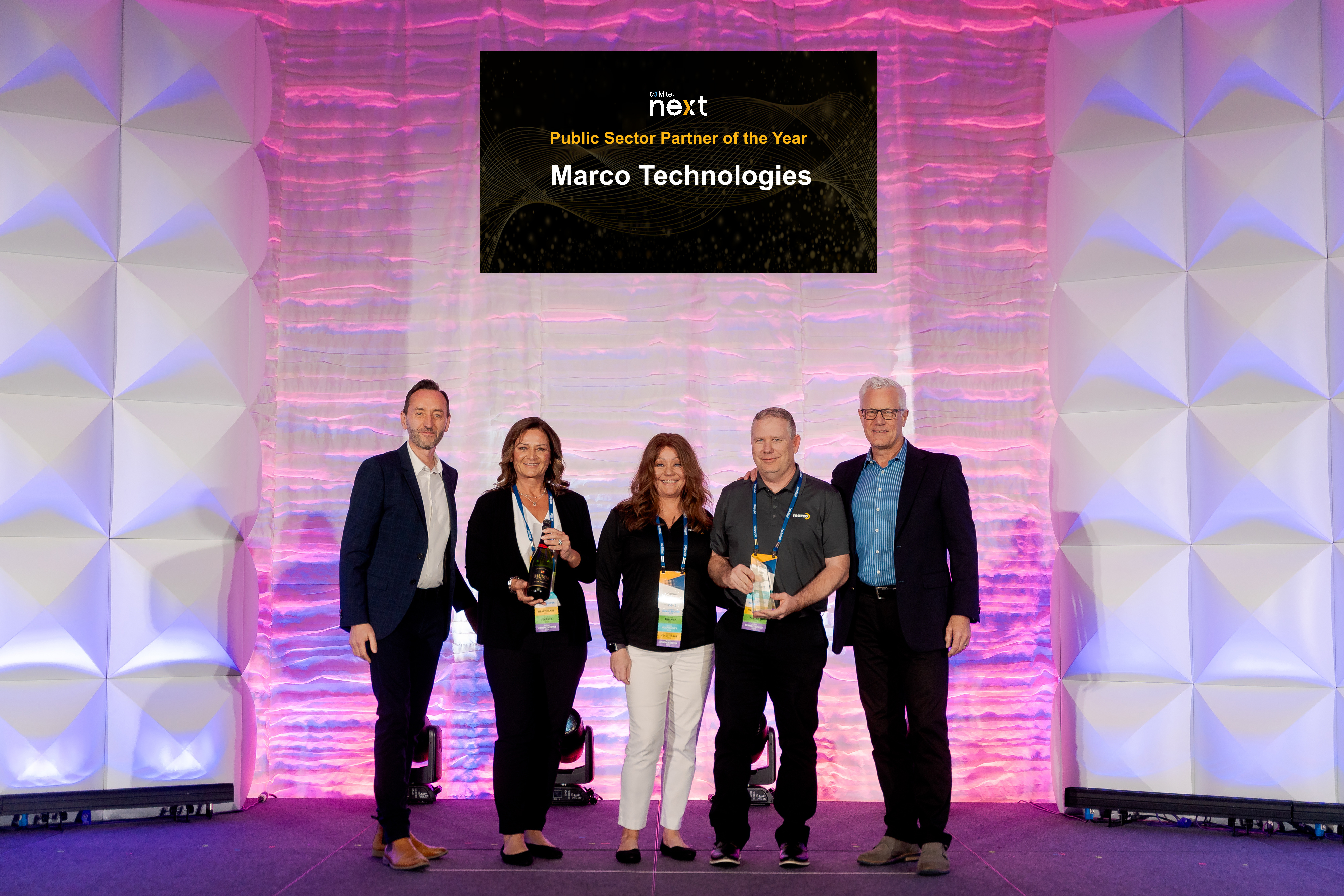 Marco Technologies employees accept Mitel's Public Sector Partner of the Year award in 2024.
